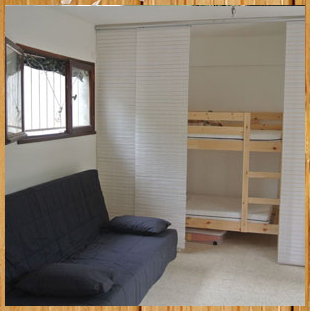 La piece a vivre avec canape et chambre d'enfants derriere les paravents japonais